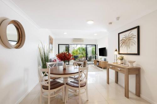 a living room with a dining room table and chairs at Spacious 2 Bed/2 Bath Garden Apartment Aircon in Brisbane