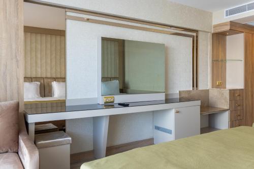 a dressing table with a mirror in a hotel room at Belenli Resort Hotel in Belek