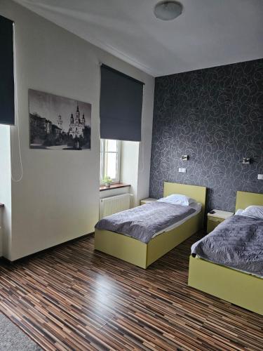 een slaapkamer met 2 bedden en een muur bij Apart in Radomsko