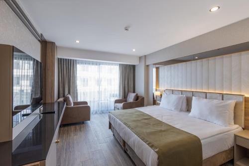 Cette chambre comprend un grand lit et une fenêtre. dans l'établissement Belenli Resort Hotel, à Belek