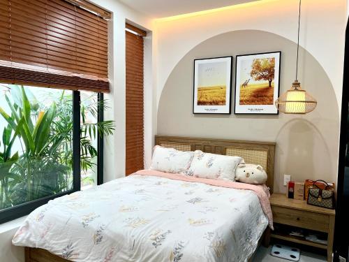 een slaapkamer met een bed en een raam bij Cozy House in Ho Chi Minh-stad