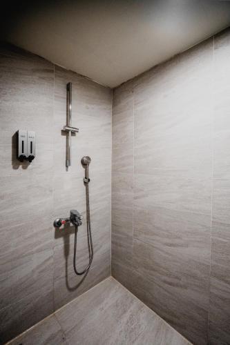 a bathroom with a shower with a shower head at Hub Hotel Kaohsiung Yawan Branch in Kaohsiung