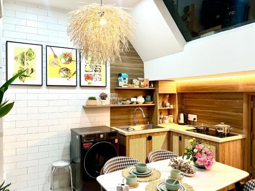 een keuken met een wastafel en een tafel met stoelen bij Cozy House in Ho Chi Minh-stad