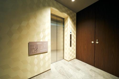 a hallway with a glass door and a wall at Rakuten STAY Kokura Station in Kitakyushu