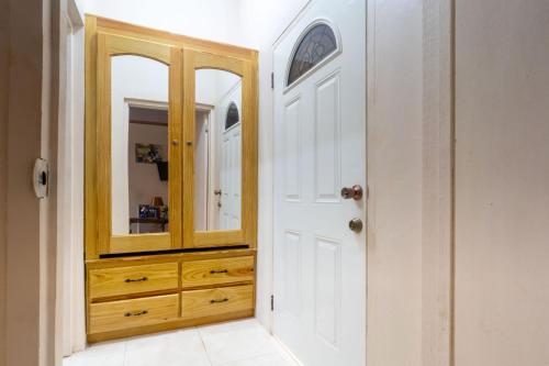 a bathroom with a wooden cabinet and a mirror at Eleven30 Luxury Apartment 1B in Negril