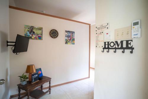 a hallway with a white wall with a home sign on it at Eleven30 Luxury Apartment 1B in Negril