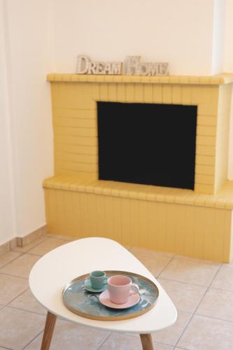 a coffee table with two cups and a plate on it at Seaside Apartments in Áyios Vasílios