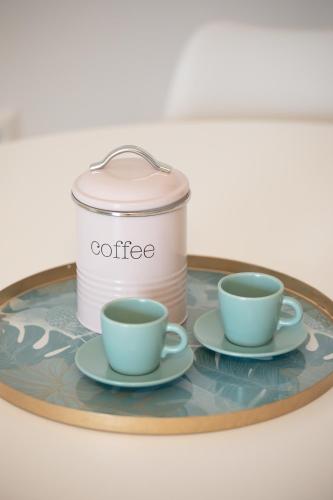 a tray with two cups and a can of coffee at Seaside Apartments in Áyios Vasílios