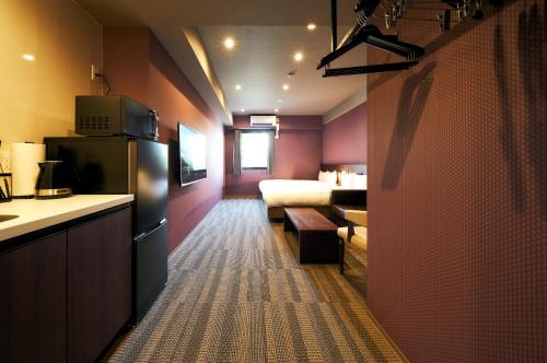 a hotel room with a kitchen and a bedroom at Rakuten STAY Kokura Station in Kitakyushu