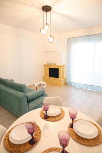 a living room with a table with wine glasses on it at Seaside Apartments in Áyios Vasílios