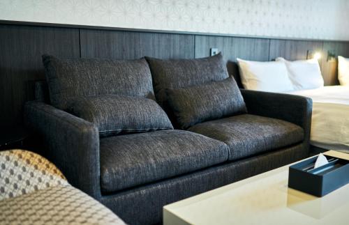 a living room with a couch and a bed at Rakuten STAY Kokura Station in Kitakyushu