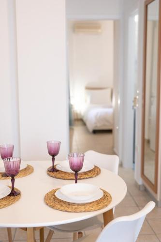 a table with three purple wine glasses on it at Seaside Apartments in Áyios Vasílios