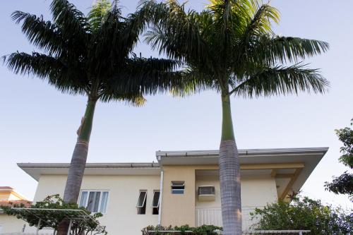 two palm trees in front of a building at Pousada Cataratas in Foz do Iguaçu