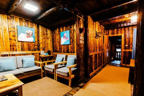 Habitación con paredes de madera, sillas y mesa. en Lost World Sanjiang Guest house, en Sanjiang