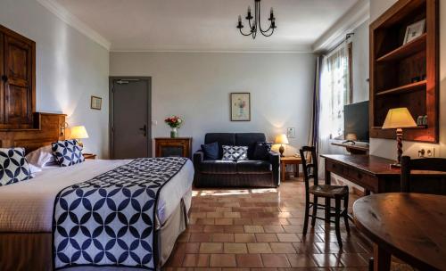 a bedroom with a bed and a couch and a desk at Charembeau in Forcalquier