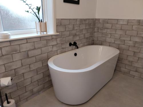 a white bath tub in a bathroom with a window at 47 Elmville Avenue in Scarborough