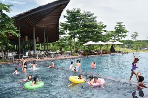 a group of people playing in a swimming pool at Villa Owner tại khu nghỉ dưỡng sinh thái Đại Lải Resort in Ngọc Quang