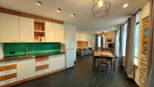 a kitchen with white cabinets and a table and a dining room at Casa Cuba Asiago in Asiago