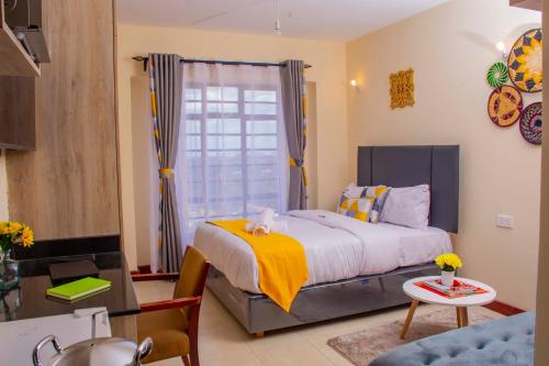 1 dormitorio con 1 cama grande y 1 mesa en South Suites studio Apartment In South B, en Nairobi