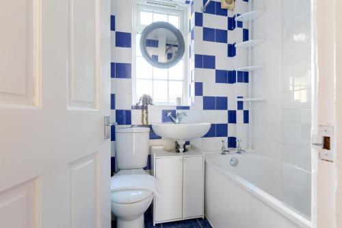 a blue and white bathroom with a toilet and a sink at The Morden Hall Collection in Morden