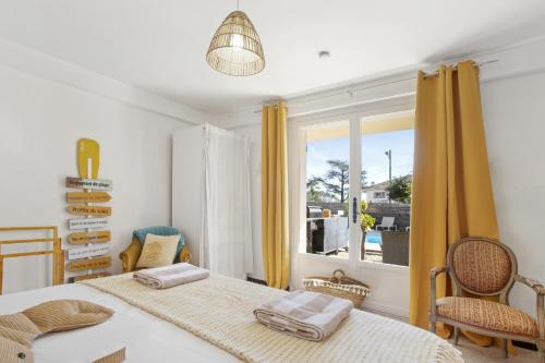 a bedroom with two beds and a window at Appartement Le Figuier in Fréjus