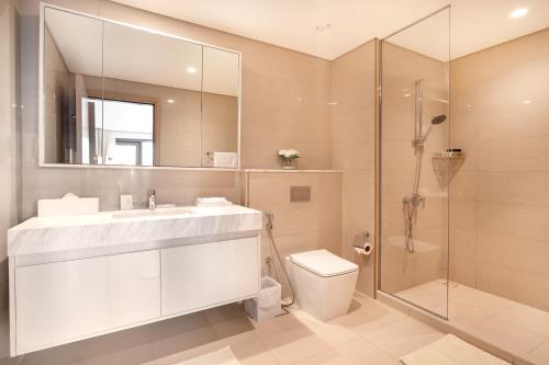 een badkamer met een wastafel, een toilet en een douche bij Prime Retreats @ Burj Royale By Emaar in Dubai
