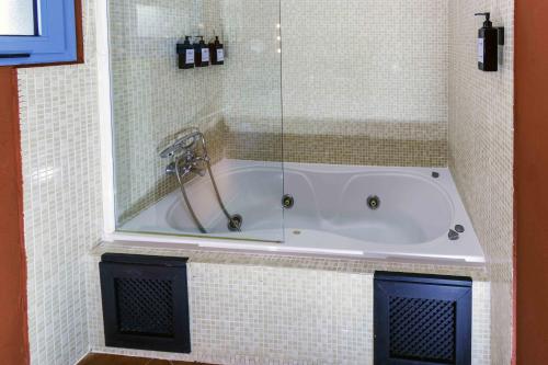a bath tub in a tiled bathroom with a shower at Hotel Utopía in Benalup Casas Viejas