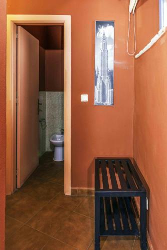 a bathroom with a toilet and a bench in it at Hotel Utopía in Benalup Casas Viejas