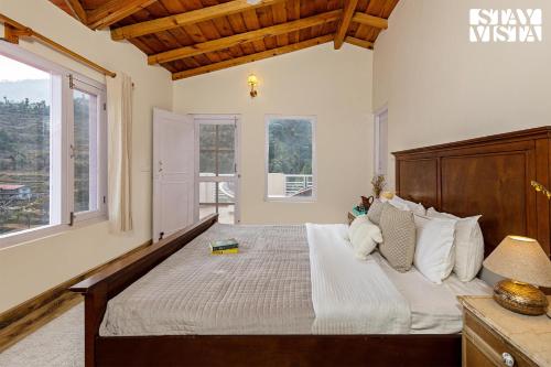 1 dormitorio con 1 cama grande y cabecero de madera en StayVista at Bird's Crest Valley Villa, en Rāmgarh