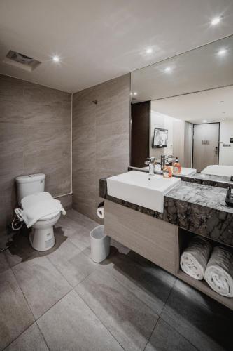 a bathroom with a tub and a toilet and a sink at Hub Hotel Kaohsiung Yawan Branch in Kaohsiung