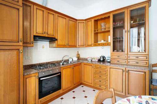 een keuken met houten kasten en een fornuis met oven bij Nonna Sere Home in Riva Ligure