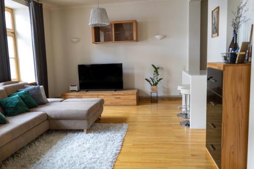 a living room with a couch and a flat screen tv at Old City Harmony Apartment in Riga