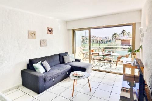 カンヌにあるPalm Beach area - 1 bedroom flatのリビングルーム(青いソファ、テーブル付)