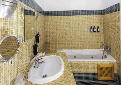 a bathroom with a tub and a sink and a mirror at Hotel Utopía in Benalup Casas Viejas