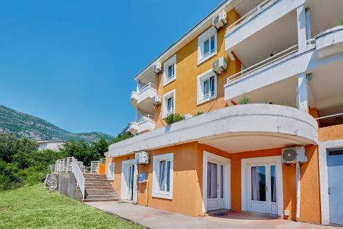 an orange building with stairs in front of it at Apartments Villa Relax in Petrovac na Moru