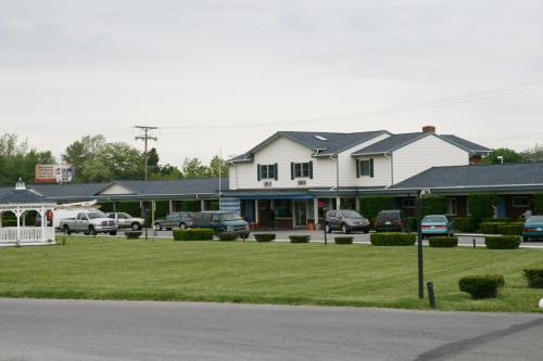 a large white house with cars parked in a parking lot at WYE Motor Lodge Duncansville - Altoona in Duncansville