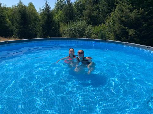 2 personnes nagent dans une piscine dans l'établissement "Le petit bonheur" Gîte van 4 tot 12 personen met privé vijver van 2Ha, à Maisonnais-sur-Tardoire
