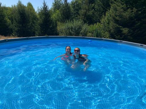 two people are swimming in a swimming pool at "Le petit bonheur" Gîte van 4 tot 12 personen met privé vijver van 2Ha in Maisonnais-sur-Tardoire