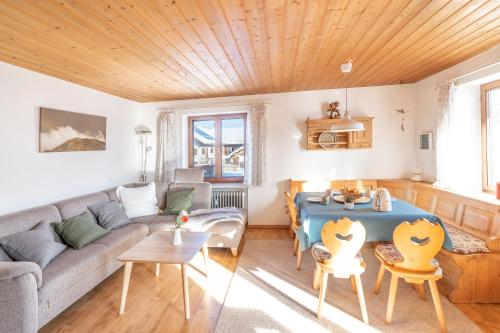uma sala de estar com um sofá e uma mesa em Fewo Simone em Rettenberg