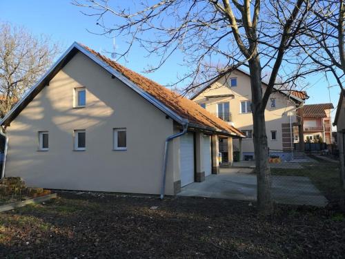 una casa blanca con techo naranja en Cozy apartment for short term rent., en Káty