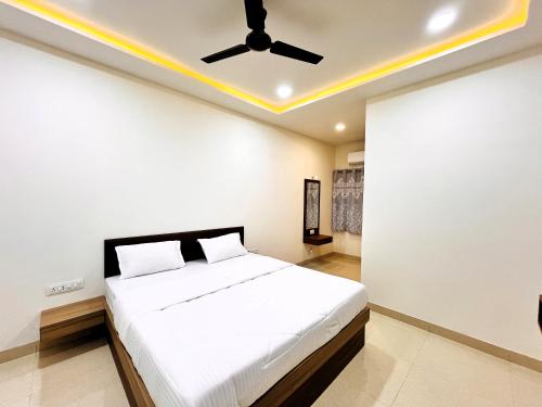 Schlafzimmer mit einem Bett und einem Deckenventilator in der Unterkunft Hotel Kutch Palace in Bhuj