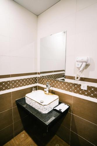 a bathroom with a sink and a mirror at Tamcoc Catalina Hotel in Ninh Binh