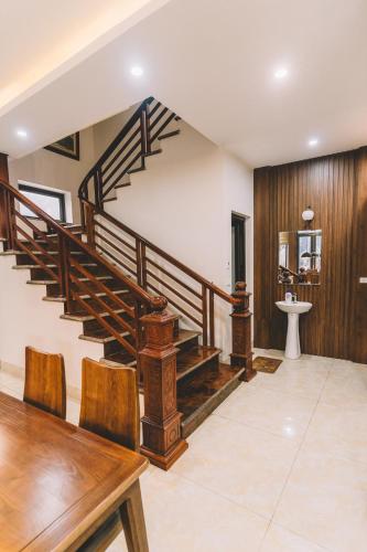 a staircase in a room with a table and chairs at Tamcoc Catalina Hotel in Ninh Binh
