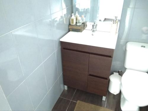 a bathroom with a white sink and a toilet at Privacidade na sua estadia no Centro do Montijo. in Montijo