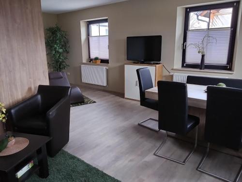 a room with a table and chairs and a tv at Auszeit-Räumlichkeiten in Dietfurt