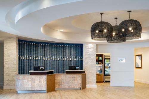 a lobby of a pharmacy with two chandeliers at Delta Hotels by Marriott Jacksonville Deerwood in Jacksonville