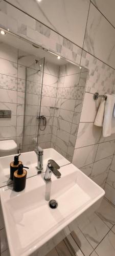 a white bathroom with a sink and a mirror at TOPAZ three in Siviri