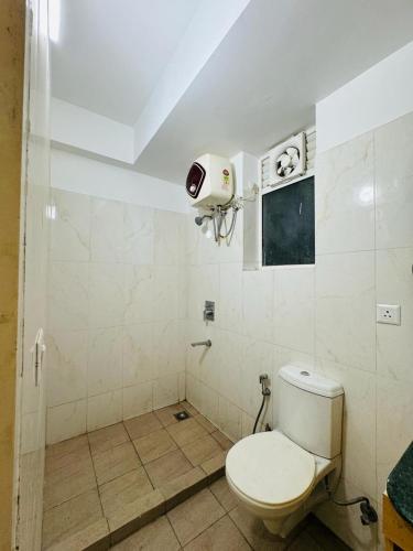 a bathroom with a white toilet in a room at ARMERIA STAY 309 in Lucknow