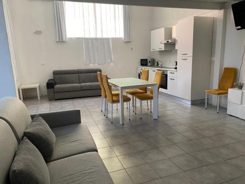 un soggiorno con un divano, un tavolo e delle sedie di la via lattea a La Spezia