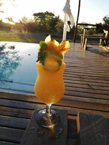 a drink in a glass sitting on a table at Tranquillity Day Spa & Lodge in Baviaanspoort
